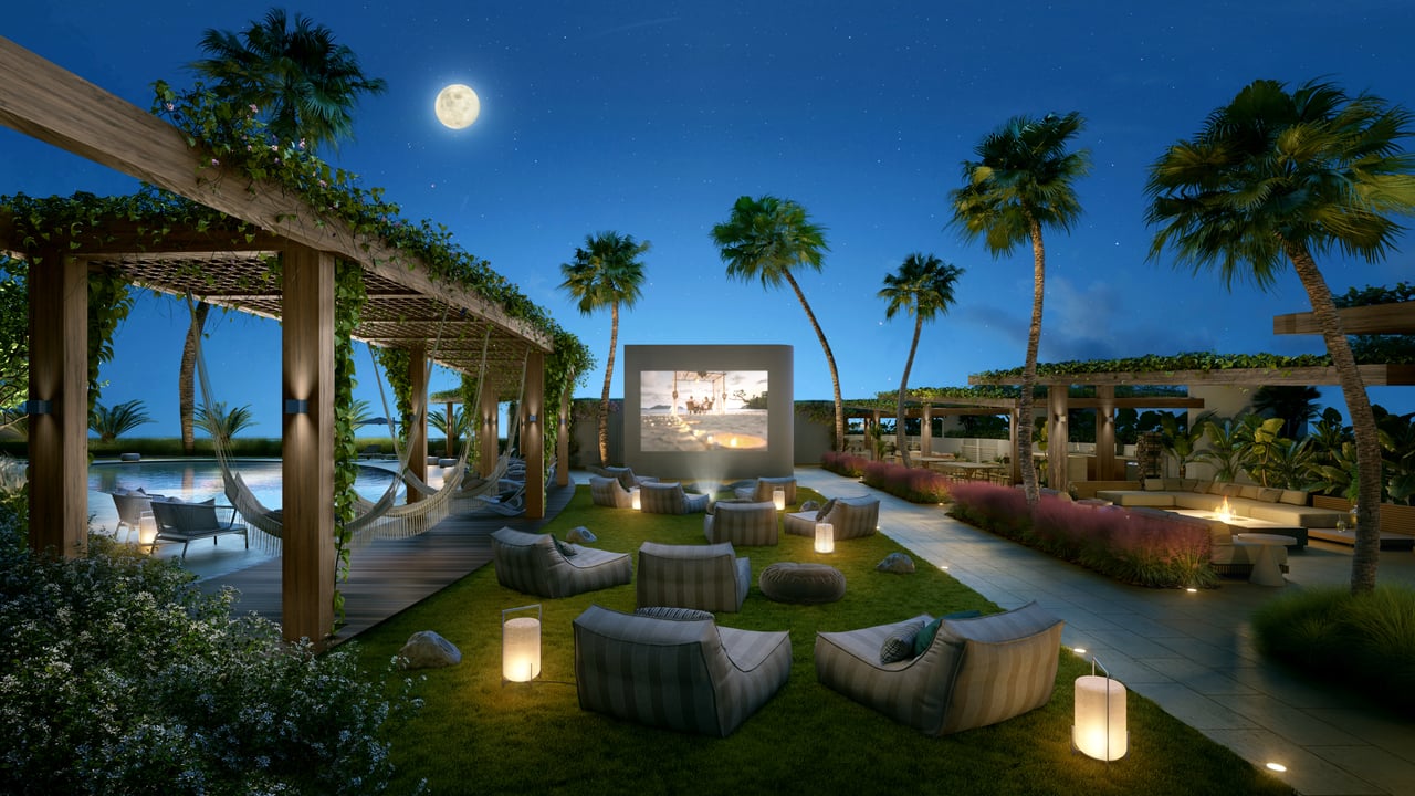 NEXO Residences’ outdoor lounge with a pool, pergolas, and seating beneath a moonlit sky.
