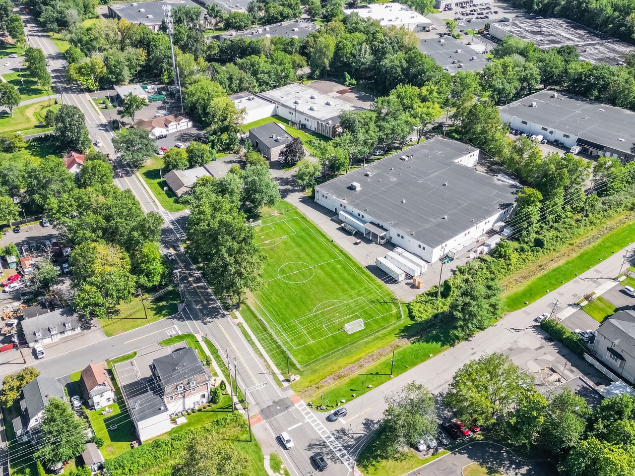 Aerial view of a Norwood, NJ athletic field surrounded by trees and residential streets