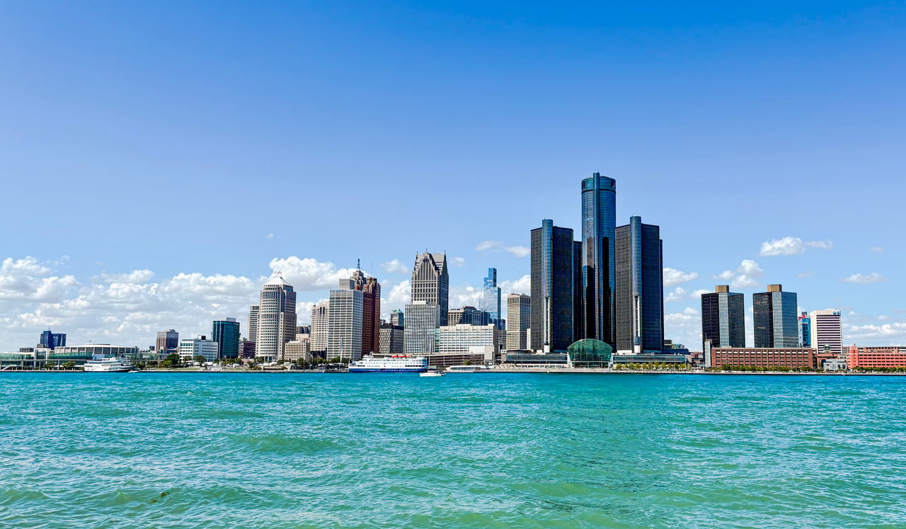 Detroit skyline across the river, with the Renaissance Center prominent along the waterfront.