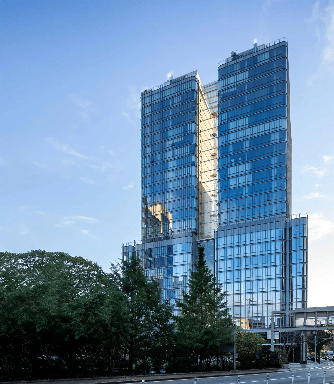 565 Broome SoHo’s twin glass towers rise above a tree-lined street.