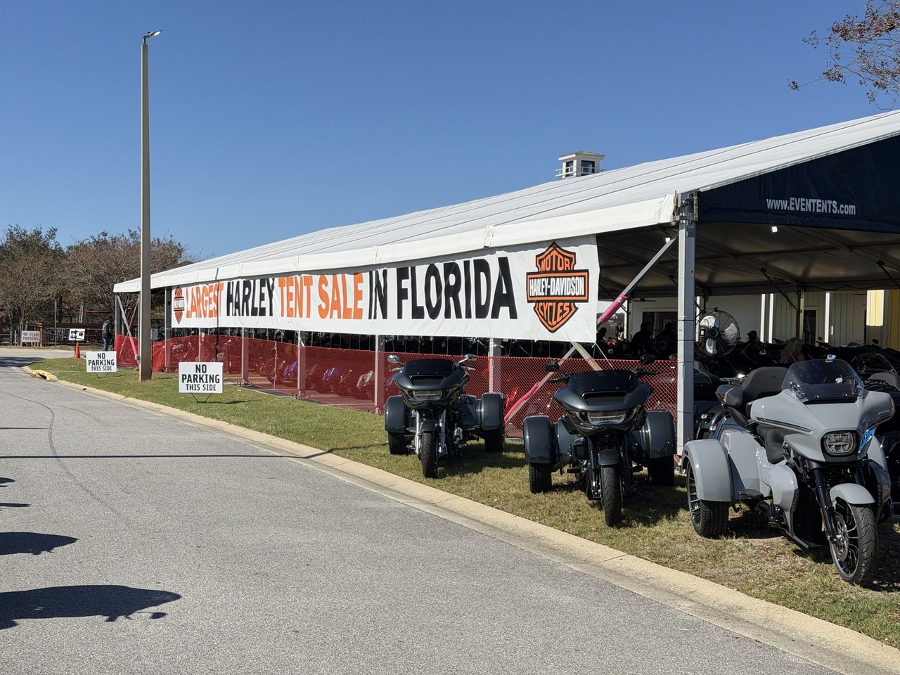 Harley-Davidson tent sale banner with trikes lined up outside Harley-Davidson of Panama City Beach