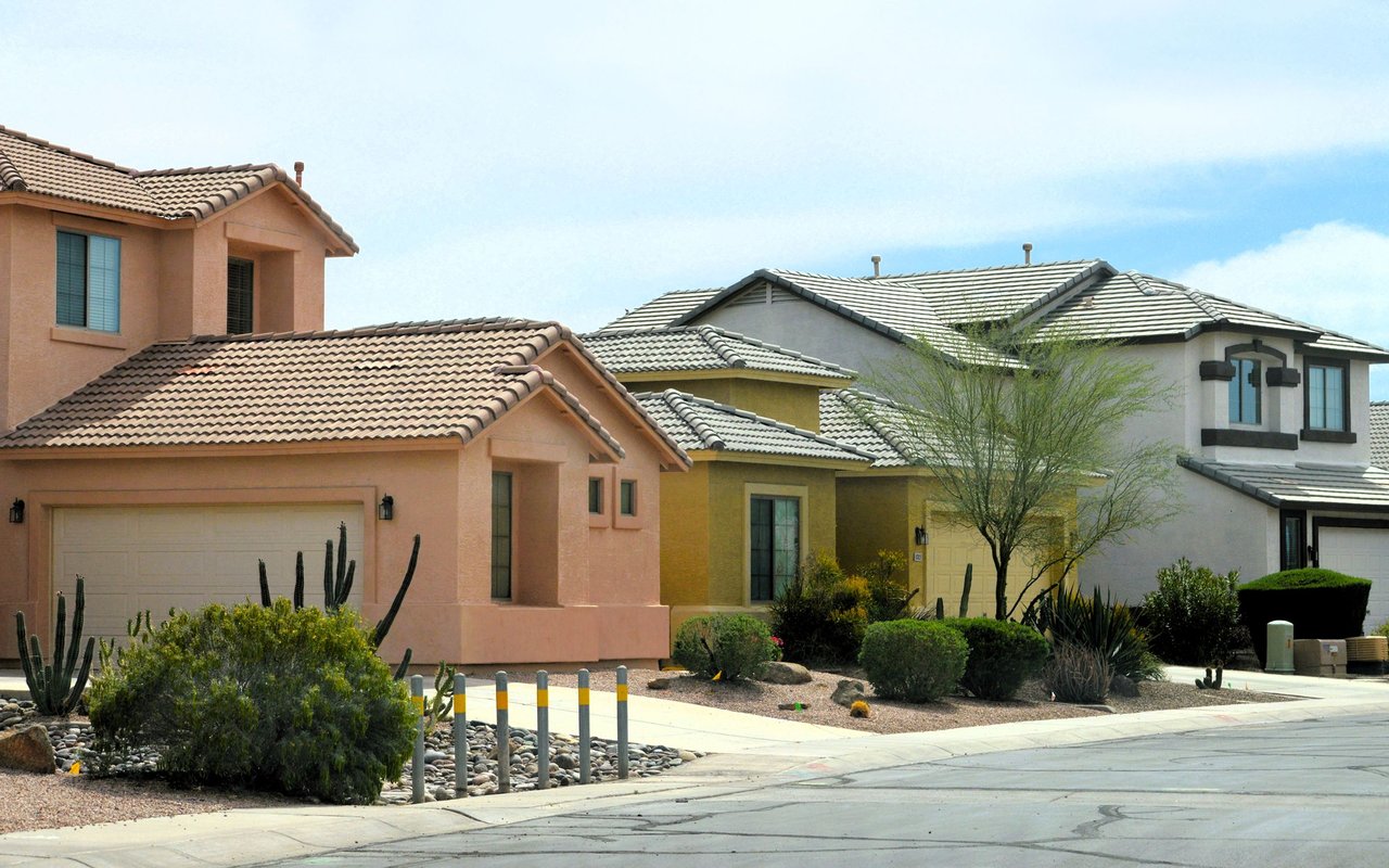 Cobblestone Farms street lined with stucco homes, tile roofs, and desert landscaping.