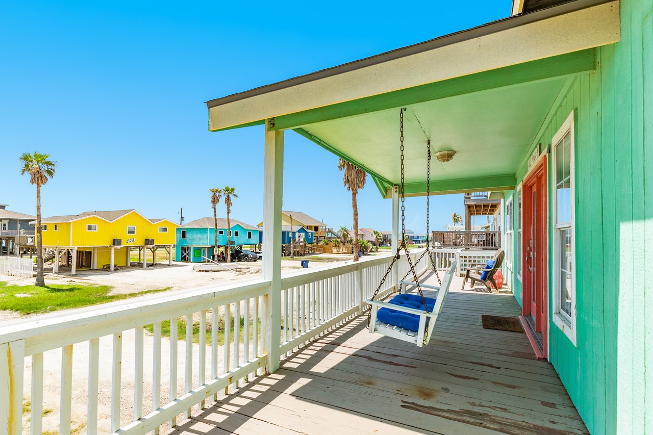 402 Seashell Front Deck, home is green with white porch swing | Cathy Carter Realtor, Carter Signature Properties.