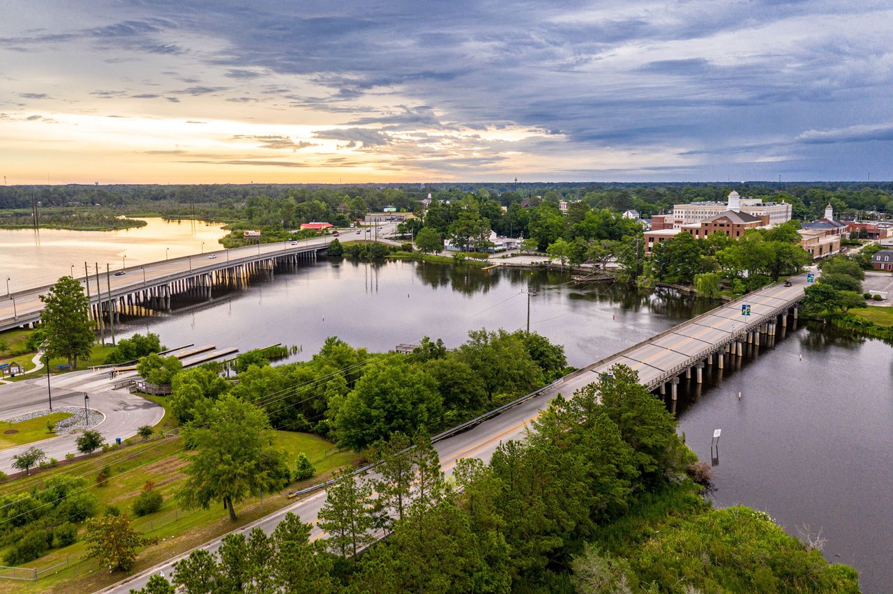 Aerial view of Jacksonville with two bridges crossing the river at sunset.