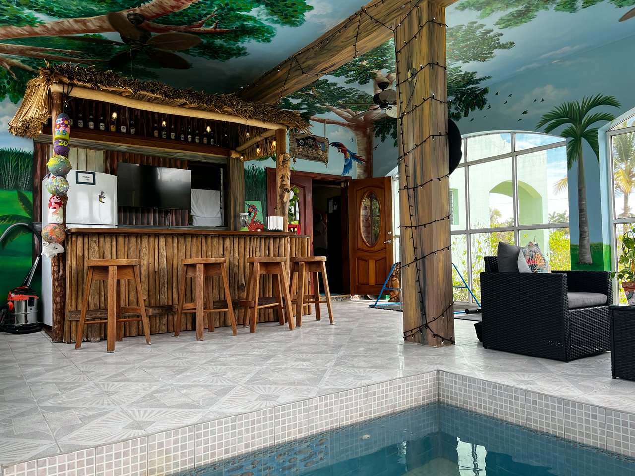 Tiki bar with murals of a tropical setting