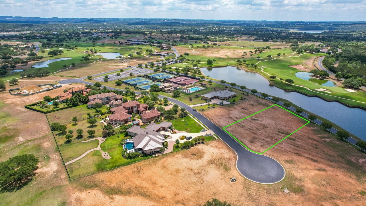 Vacant homesite outlined in green beside a pond, cul-de-sac, and golf course.