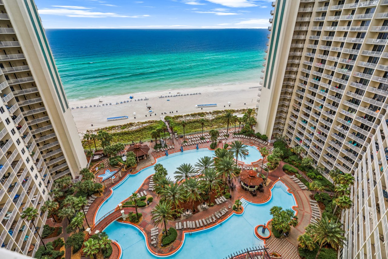 Aerial view of Panama City Beach condo towers with a resort pool and white sand beach