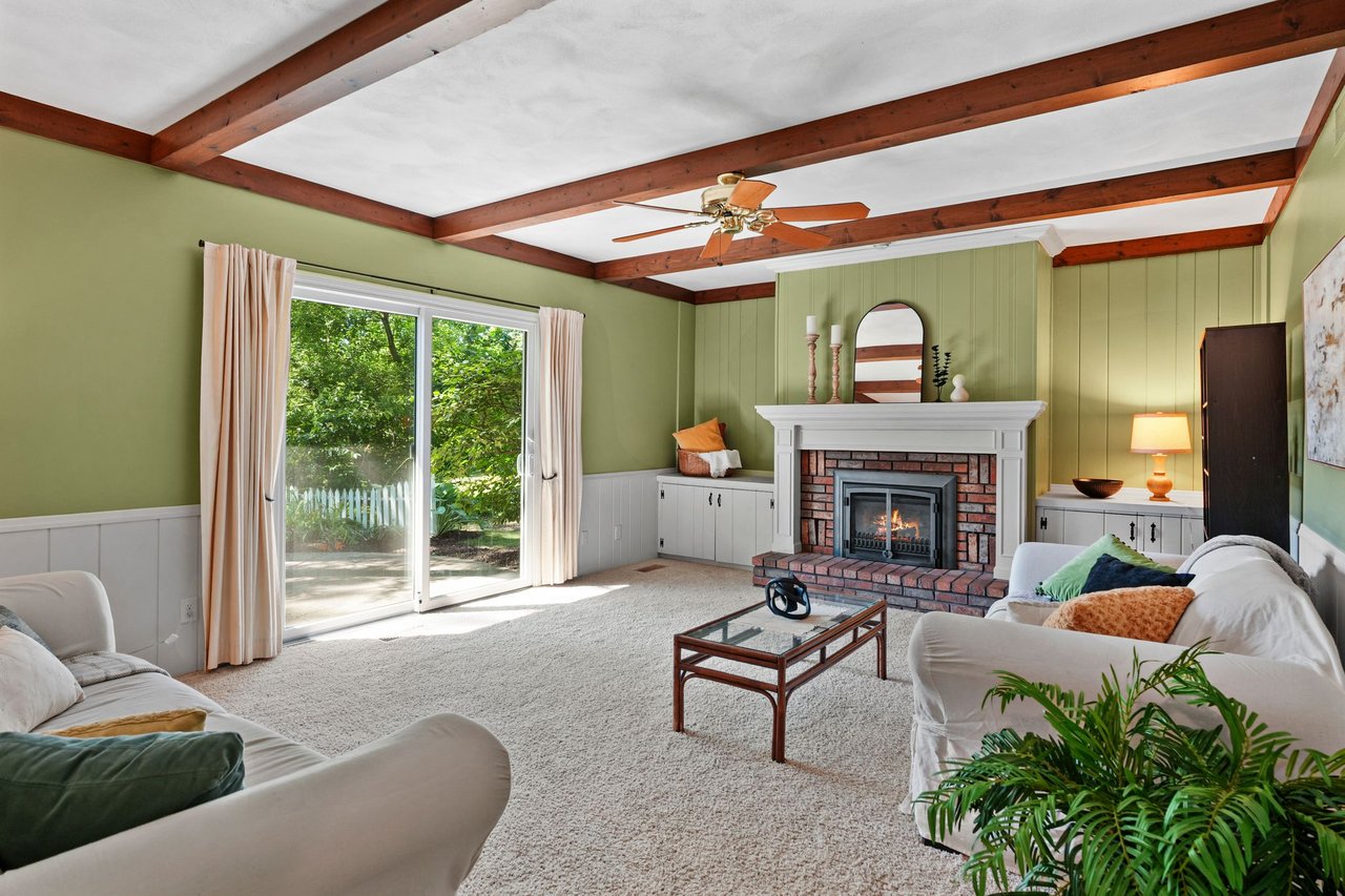 A warm, lived-in older Madison living room with a brick fireplace and wood-beam ceiling, the kind of long-owned home this disclosure guide is written for.
