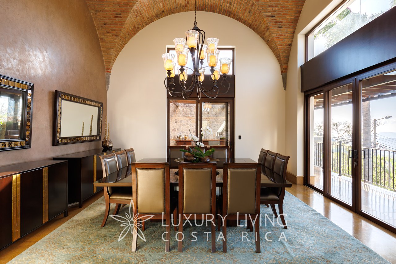Dining room with an exposed-brick arch, chandelier, and sliding doors to a terrace.