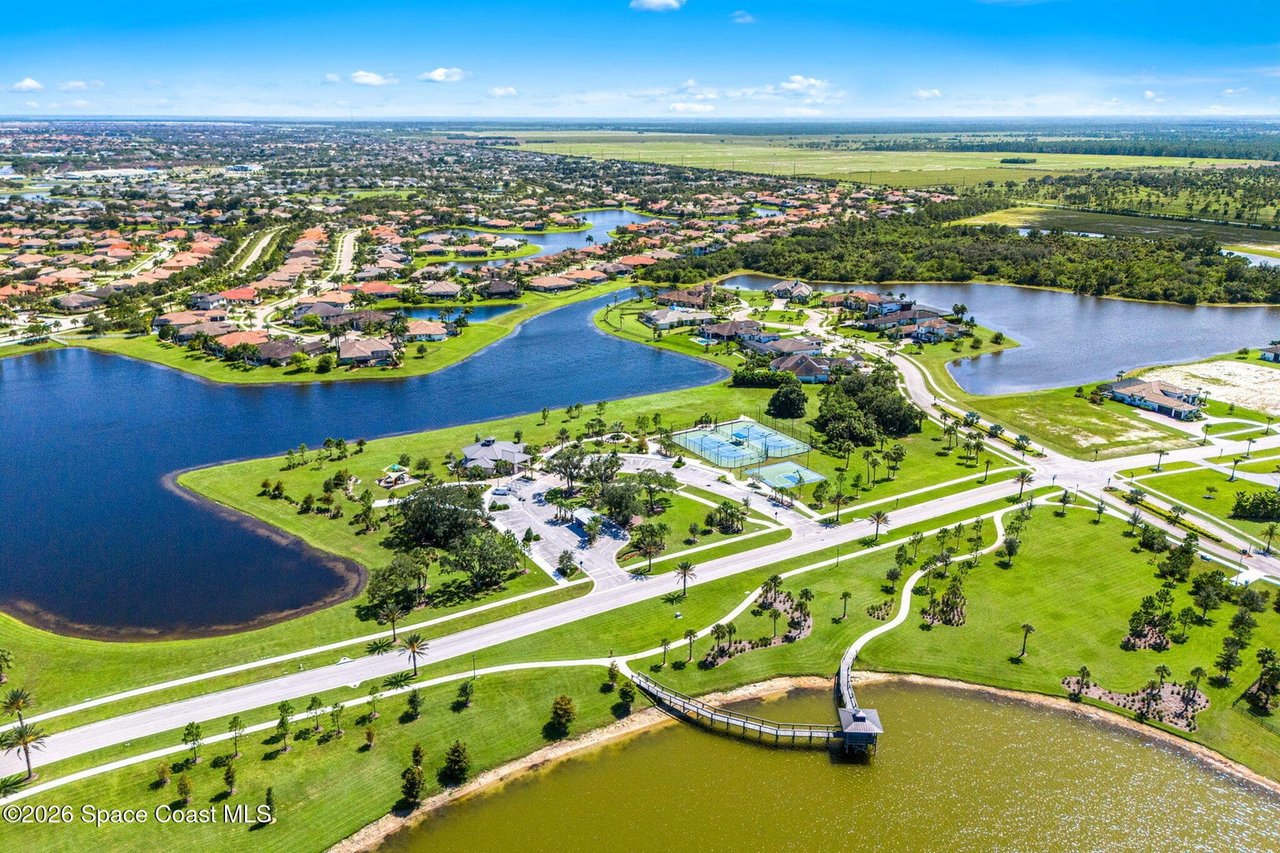 Aerial view of a lakeside neighborhood with landscaped grounds and tennis courts.
