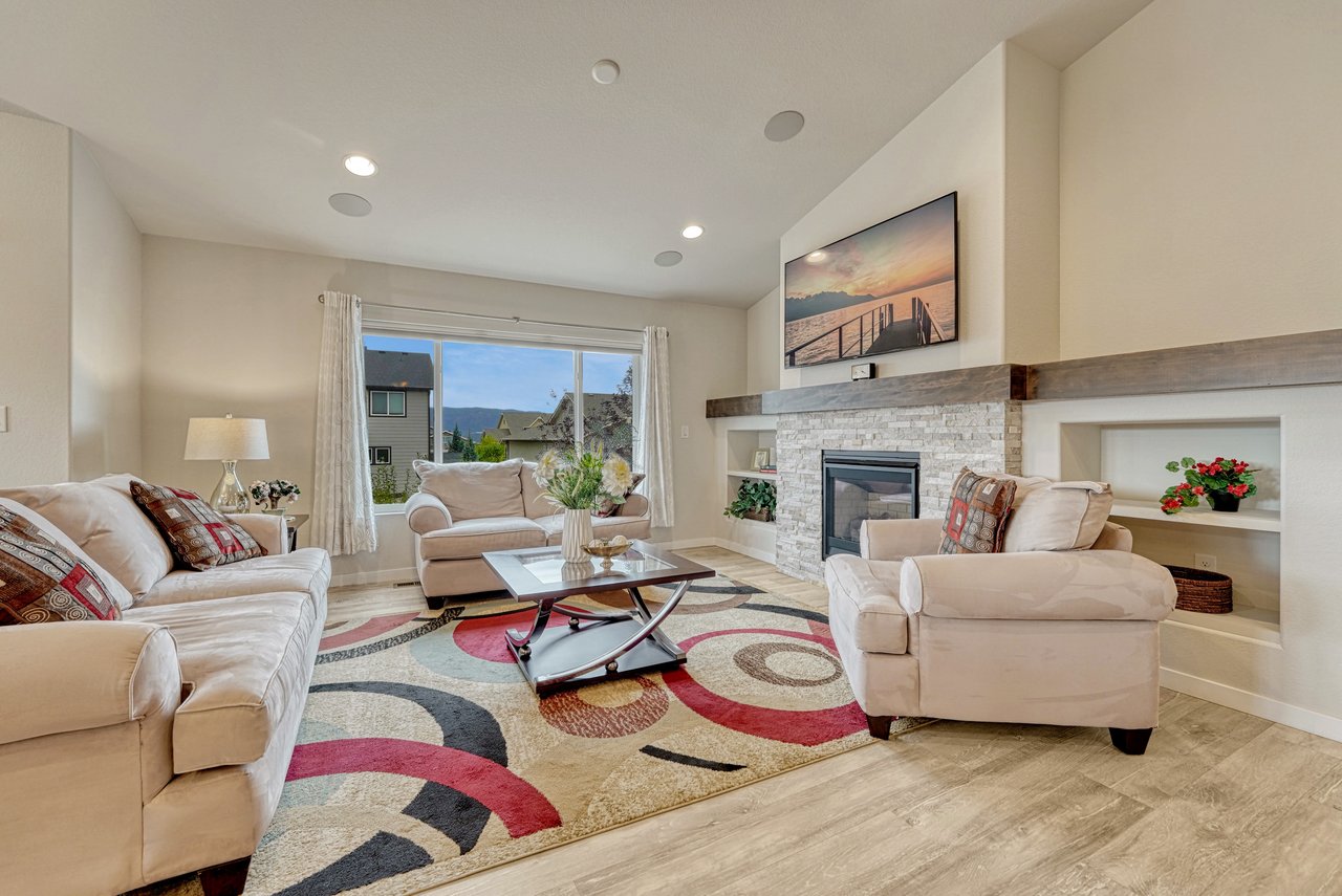 Living room with fireplace wall, built-in shelves and a large window