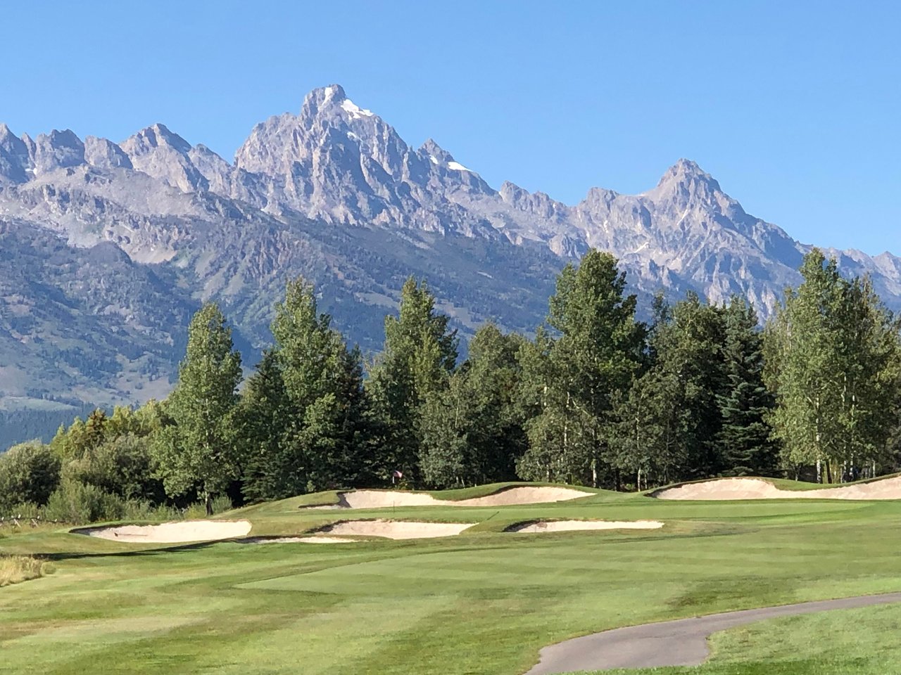 Scenic view of luxury homes with mountain backdrop at Jackson Hole Golf & Tennis, a premier neighborhood near Jackson, WY.