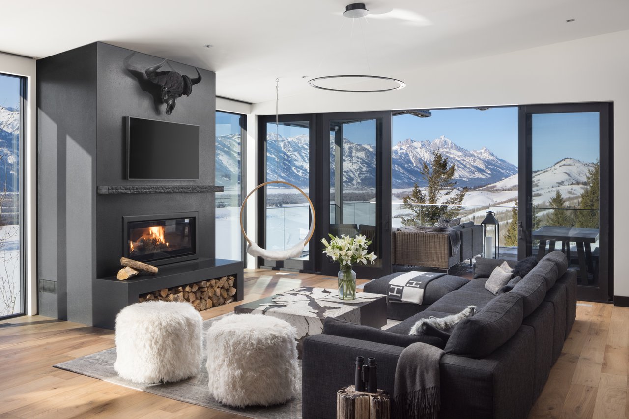 Elegant Jackson Hole living room with floor-to-ceiling windows and sweeping views of the Teton Mountains, showcasing luxury interior design.