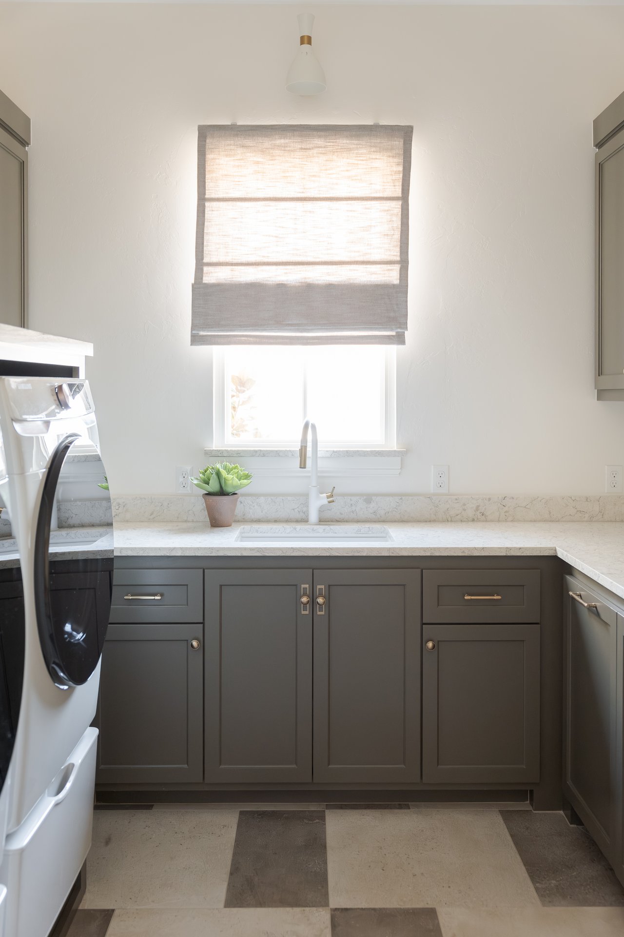 Bright and spacious laundry room with patterned tile and built-in cabinetry in a luxury Oklahoma City home, designed for both beauty and function.