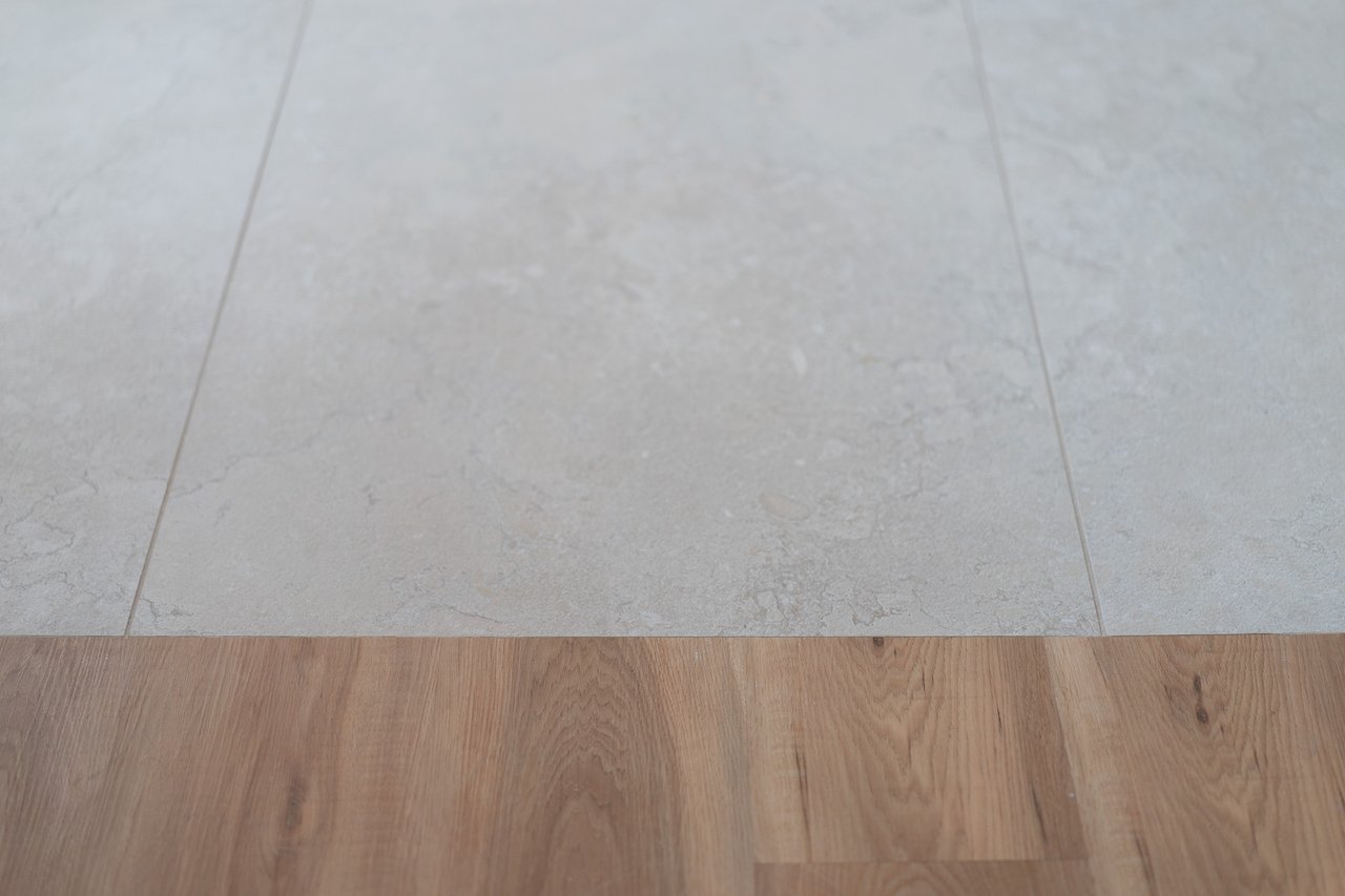 Light stone-look tile meets warm wood plank flooring.