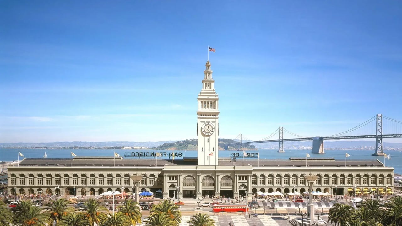 Aerial view of San Francisco Ferry Building clock tower with Bay Bridge behind