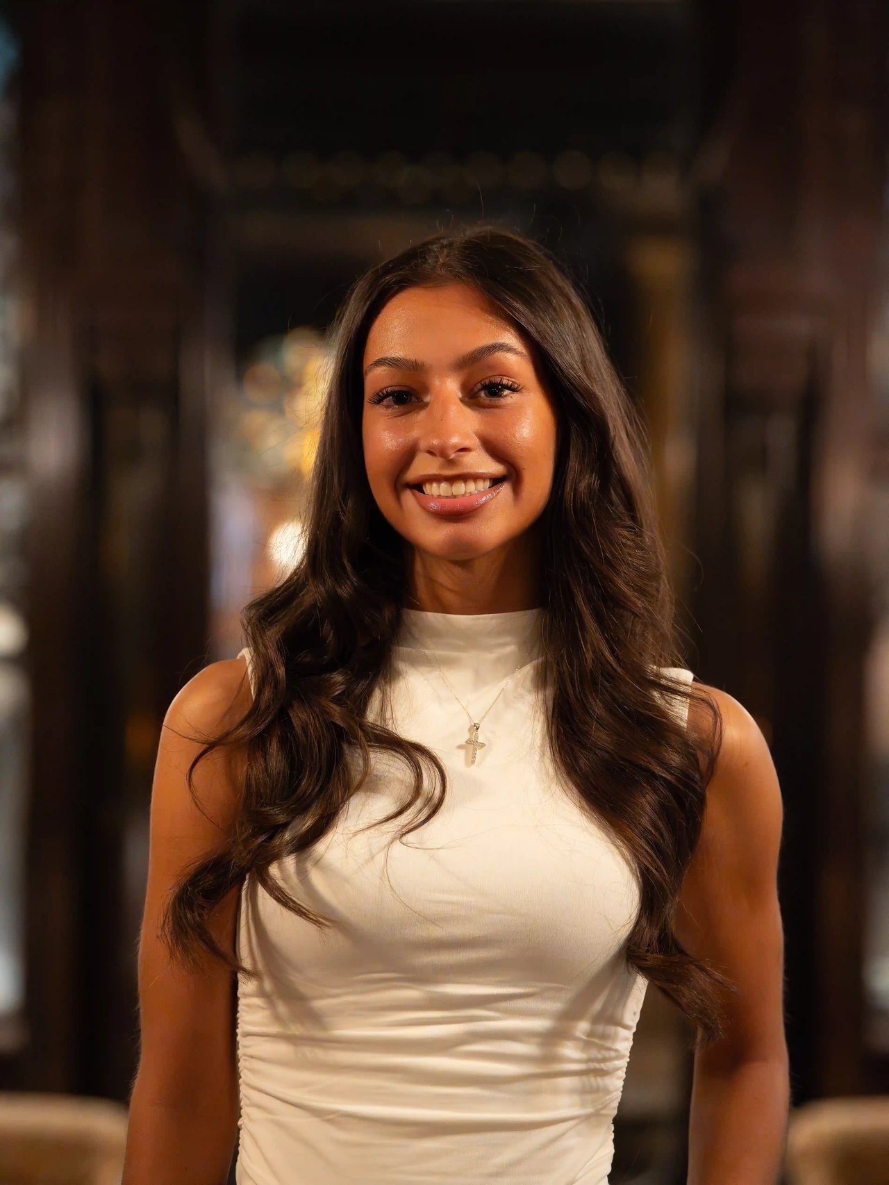Cheyanne Gruetzmacher, Milwaukee realtor with the Luxe Haven Group, smiling in a white top inside an elegant interior.