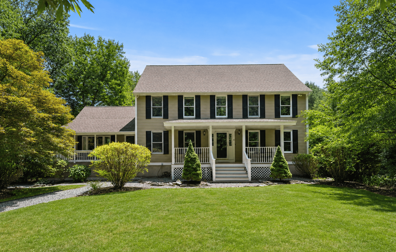 colonial home tan with black shutters and farmer's porch