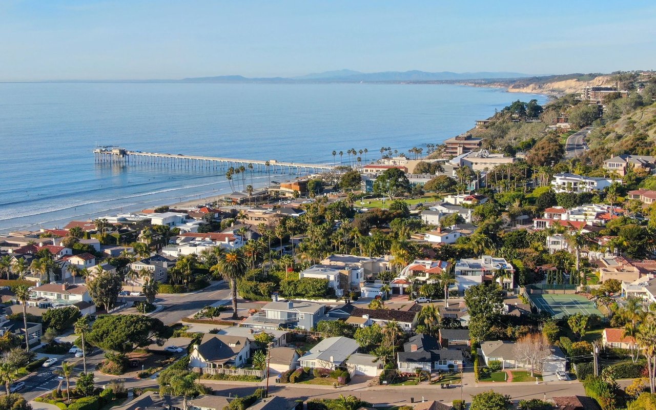 La Jolla coastline with a long pier, ocean, coastal cliffs, and homes.