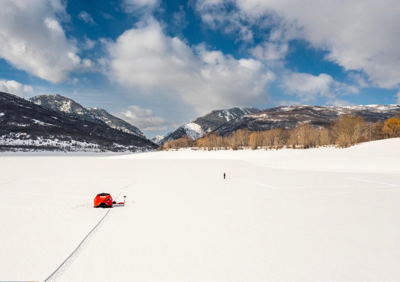 open snow field in the mountains with ski yurt
