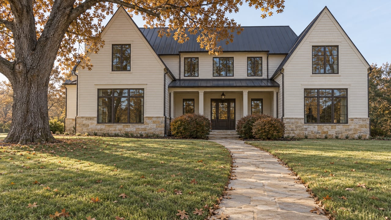 Traditional two-story ivory house with steep charcoal gables, a stone path crossing the lawn, and a mature oak.
