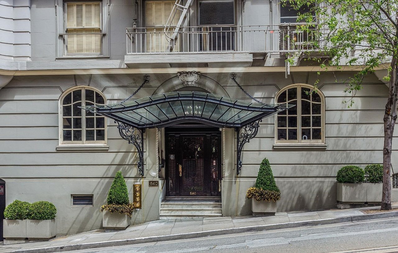 Building entrance at 840 Powell Street with an ornate glass canopy and arched windows.