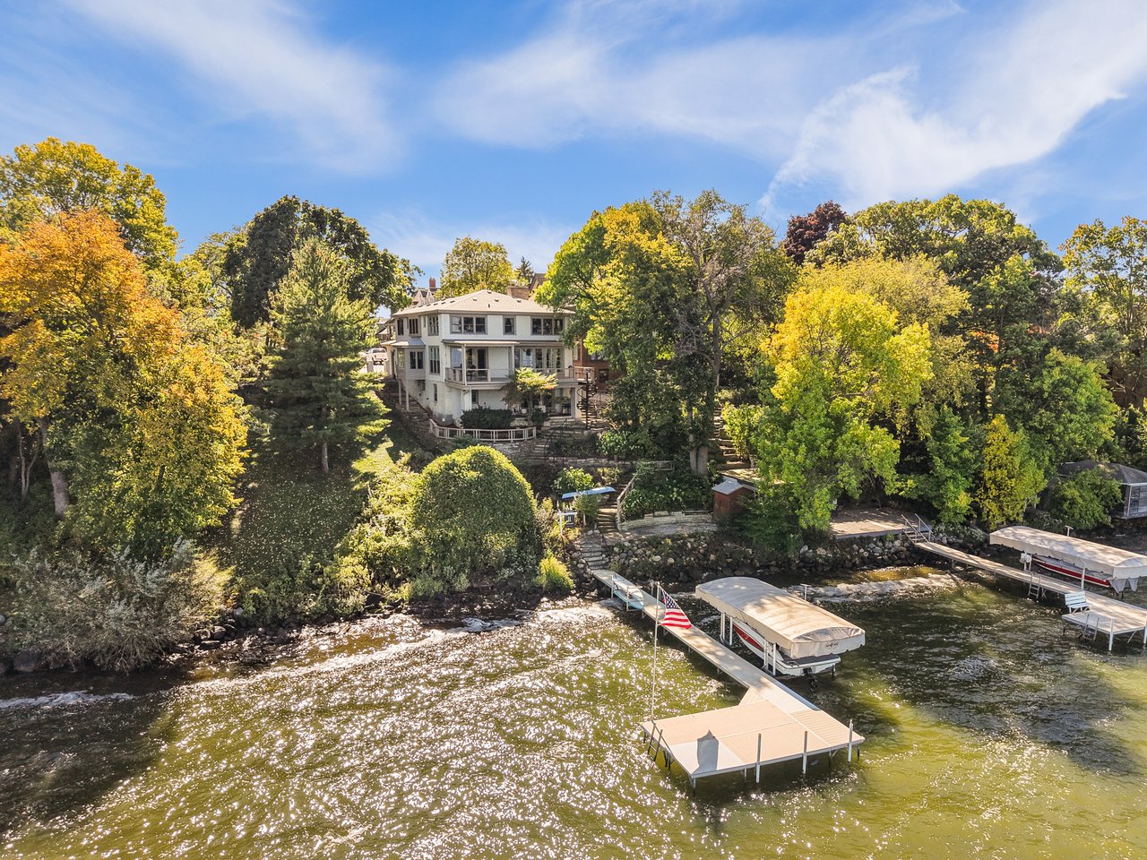 Historic William T. Evjue House beside the lake, with tree-lined grounds and multiple docks.