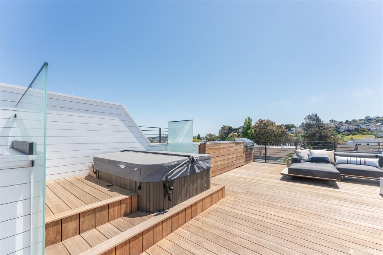 Rooftop deck with hot tub, wood flooring, and hillside views