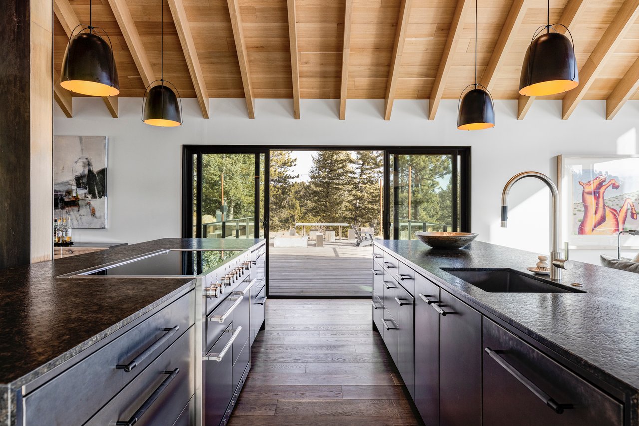 Galley kitchen in Boulder home with parallel counters, black cabinets, and outdoor deck access through sliding doors