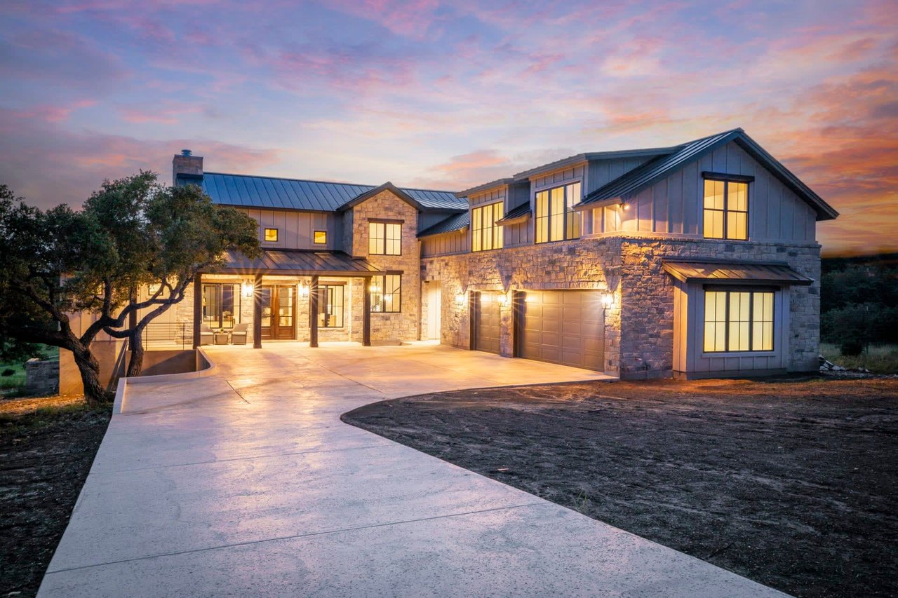 A large house with a lot of windows is bathed in the warm light of a sunset.