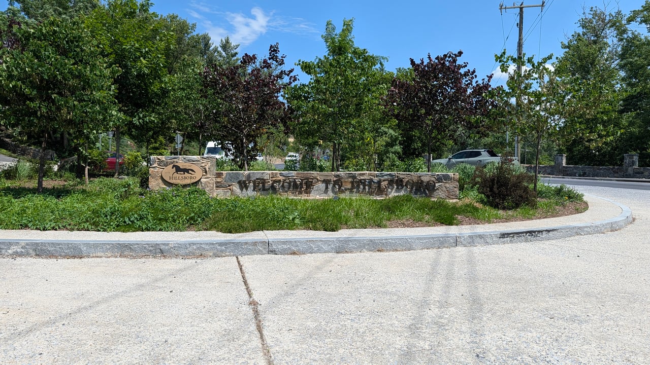 The landscaped stone wall and 'Welcome to Hillsboro' monument sign greeting visitors in Hillsboro, VA, documented by local real estate expert Diane Geremia.