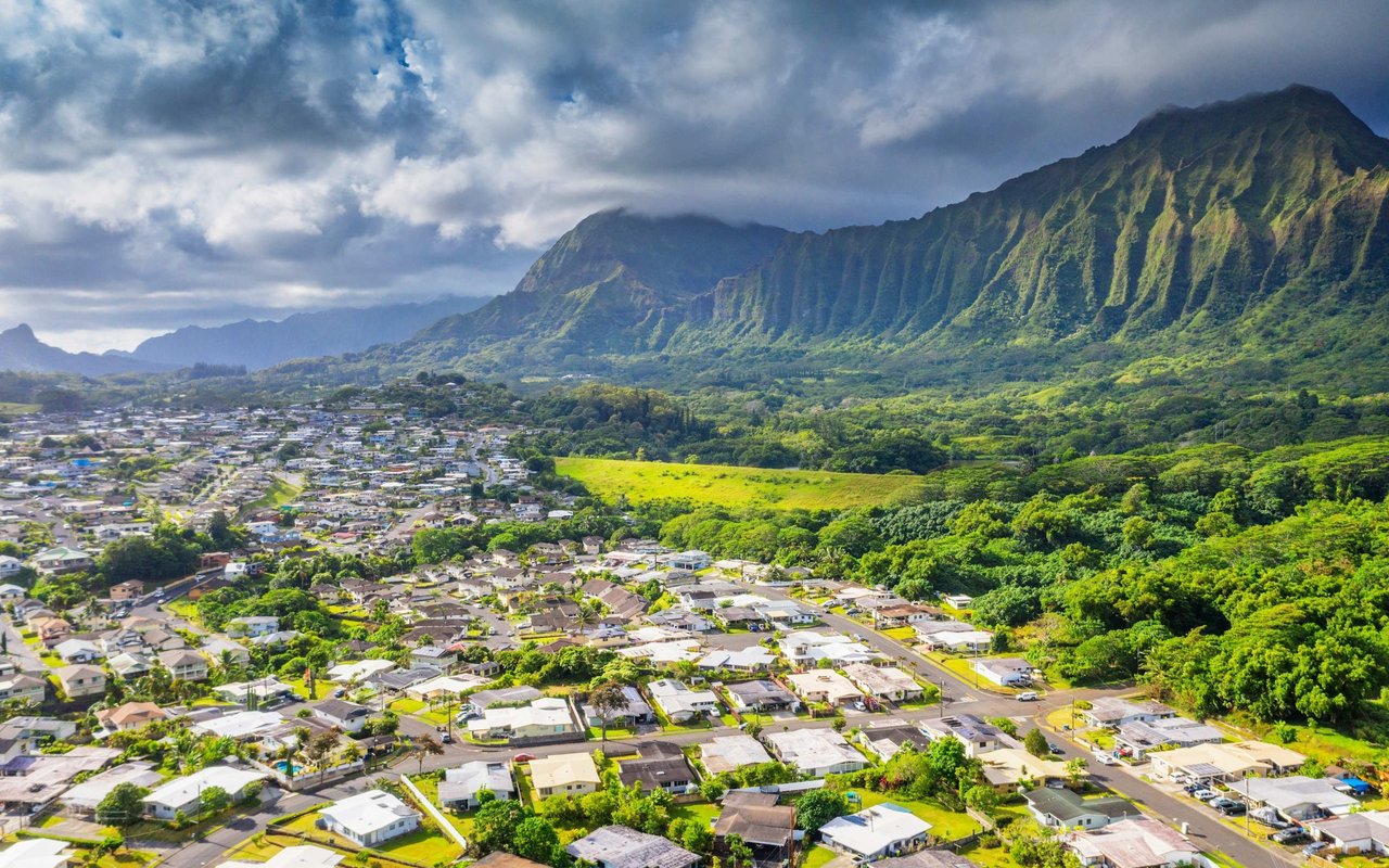 Aerial view of Kailua homes with the lush, ridged Koʻolau mountains behind them.