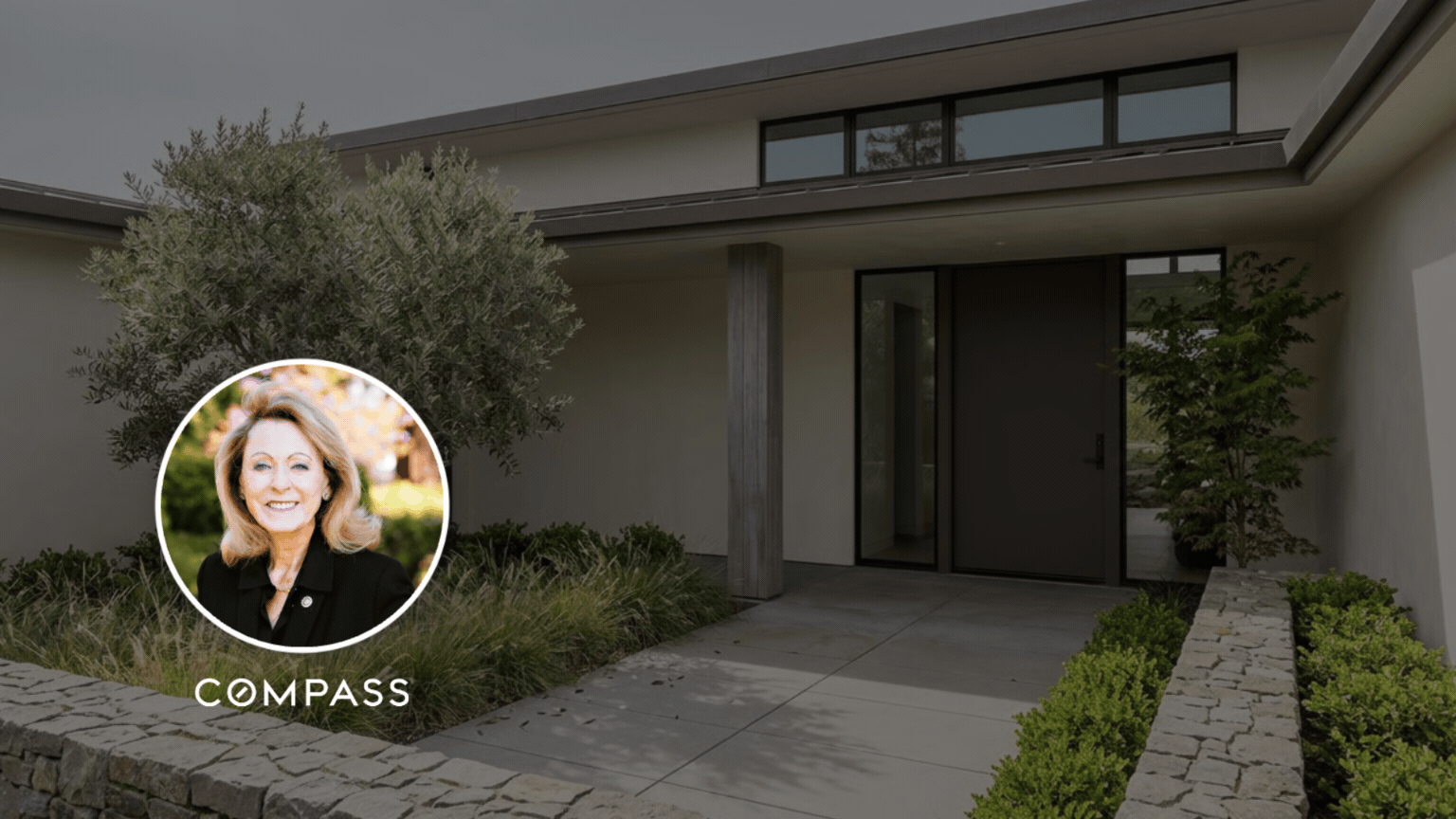 Modern home's landscaped entrance with dark-framed glass doors and a COMPASS logo overlay.