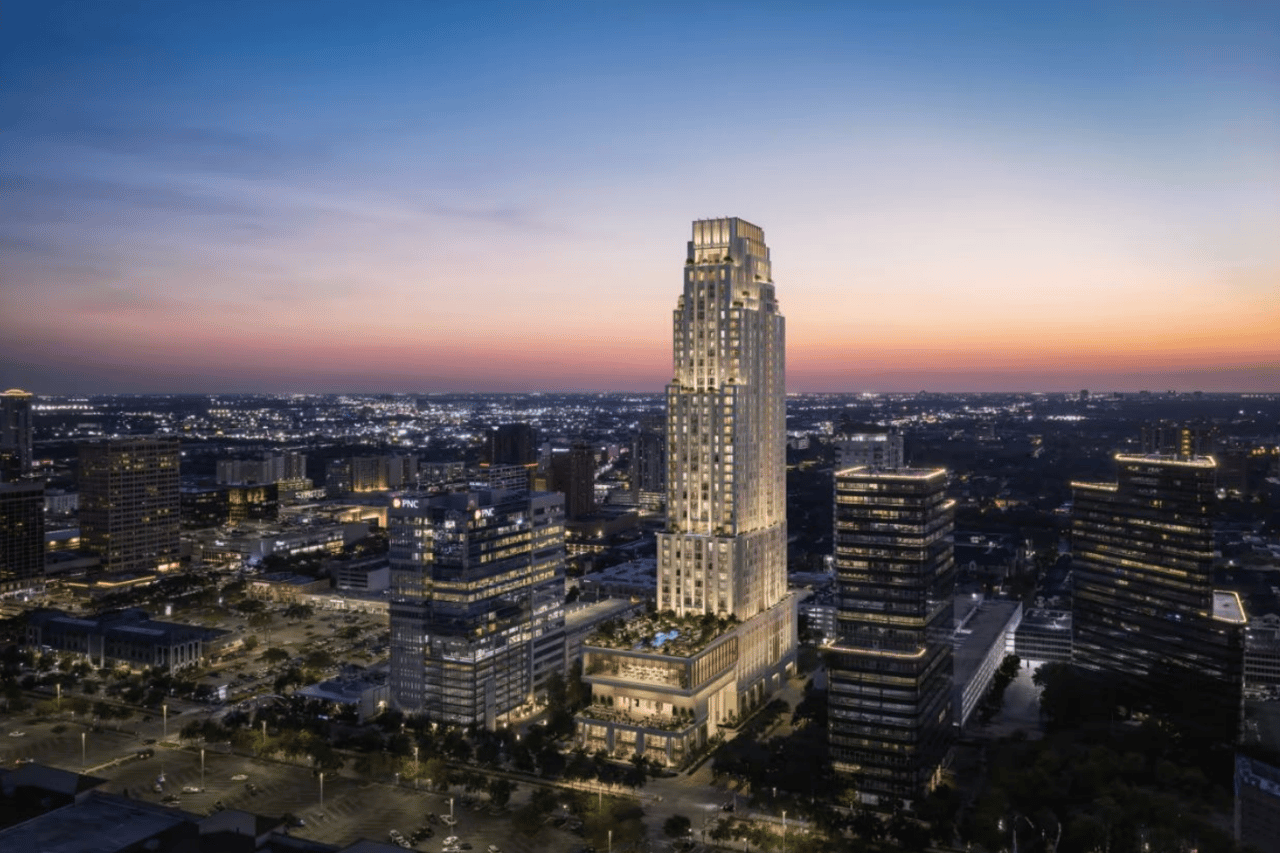 Downtown Houston skyline at dusk, with an illuminated high-rise tower centered above surrounding office buildings.