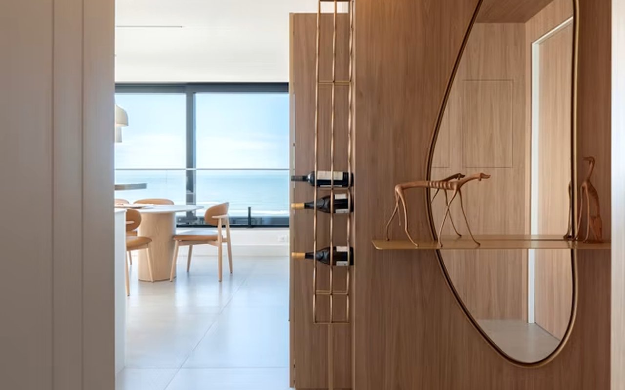Wood-paneled entry with an oval mirror, opening to a dining area overlooking the water.