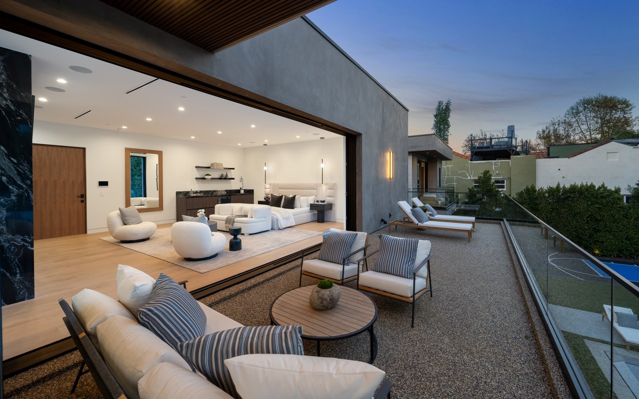 Image of benches and sofas above a nearby pool. With white lights and white painted walls on the interior and an open wall.