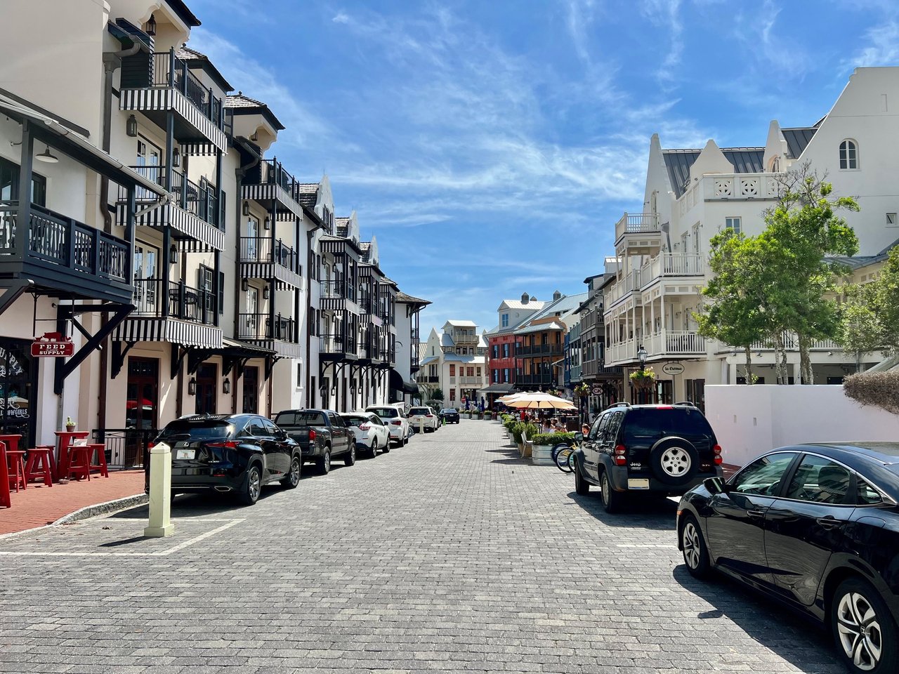 Cobblestone street lined with coastal-style buildings and balconies in Rosemary Beach.