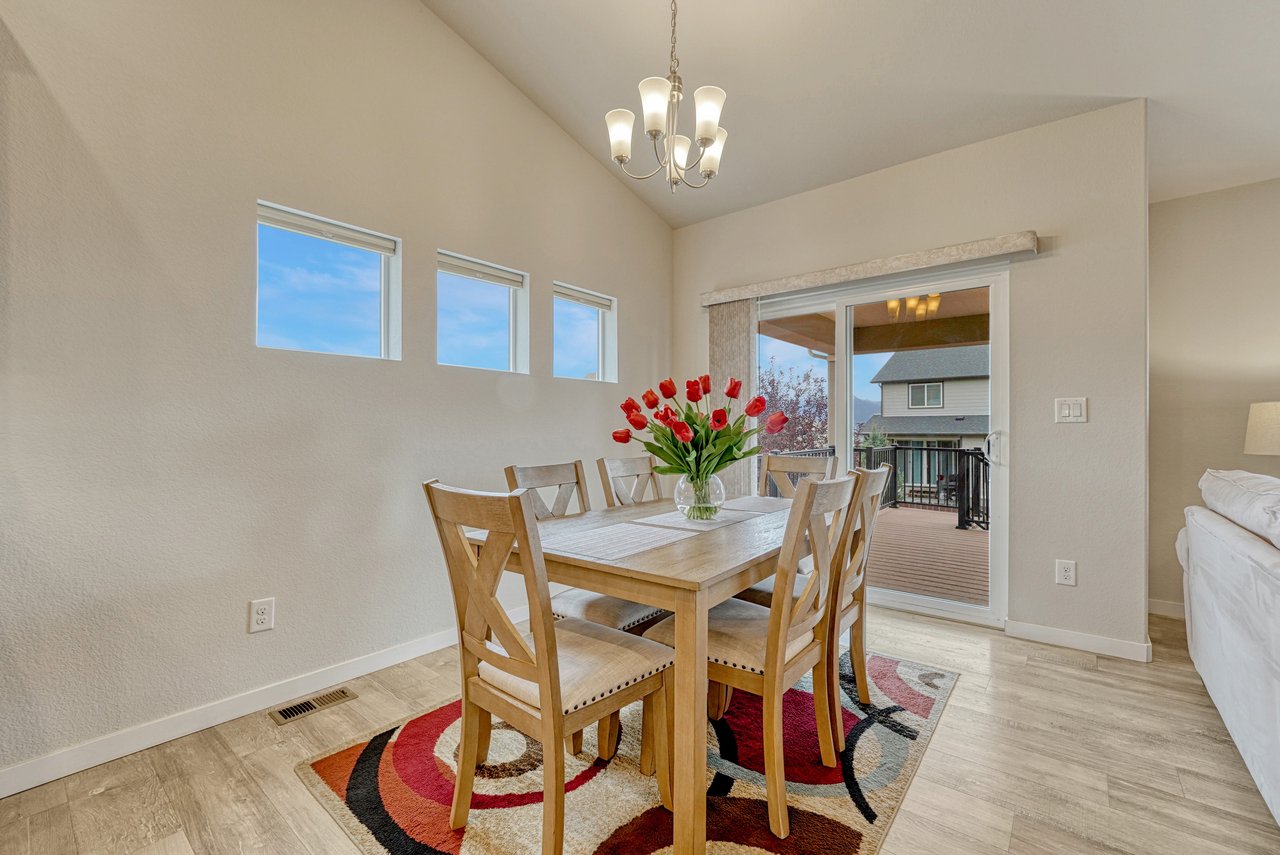 Dining area with chandelier, clerestory windows and sliding door to the deck