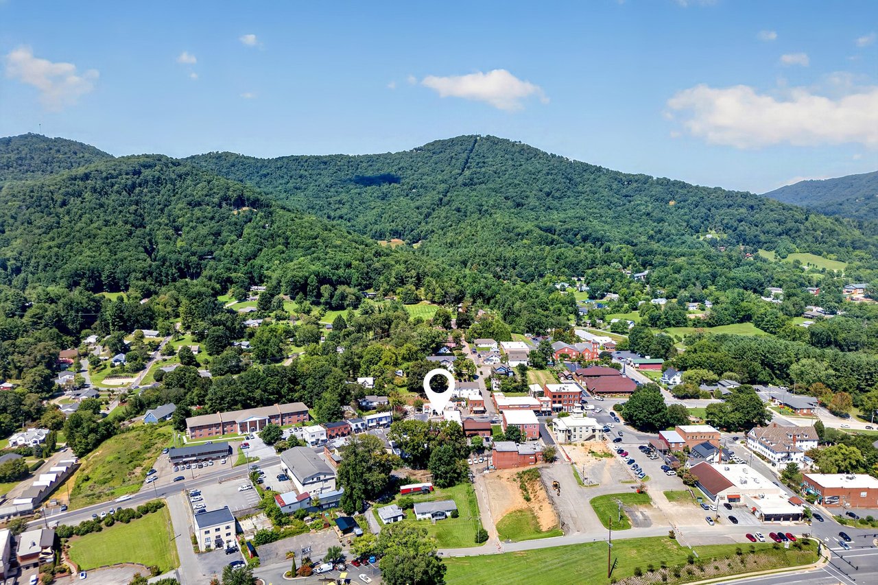 Aerial view of downtown Burnsville with a location marker, surrounded by forested mountains.