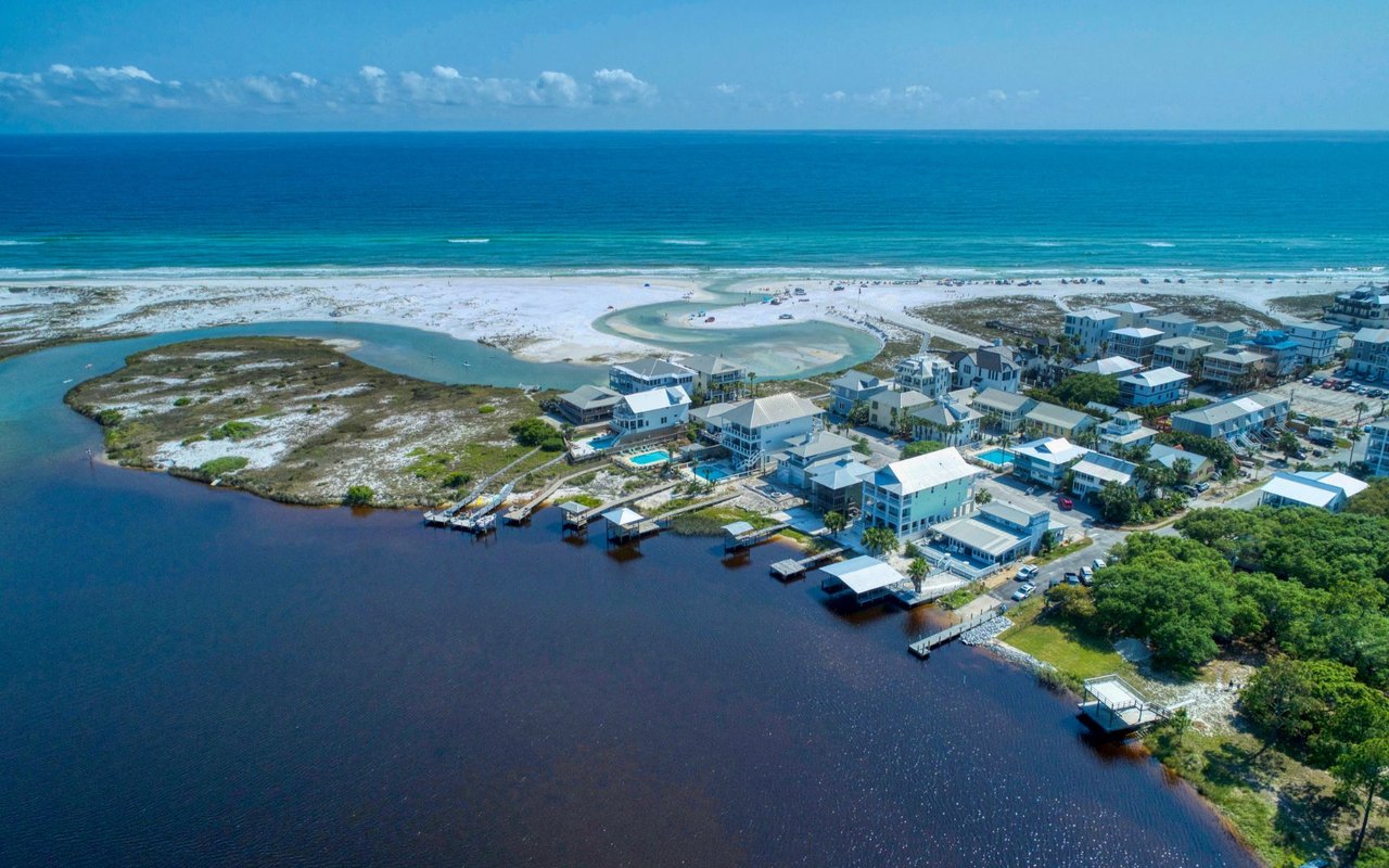 Aerial view of Grayton Beach homes between the Gulf shoreline and a coastal lagoon.