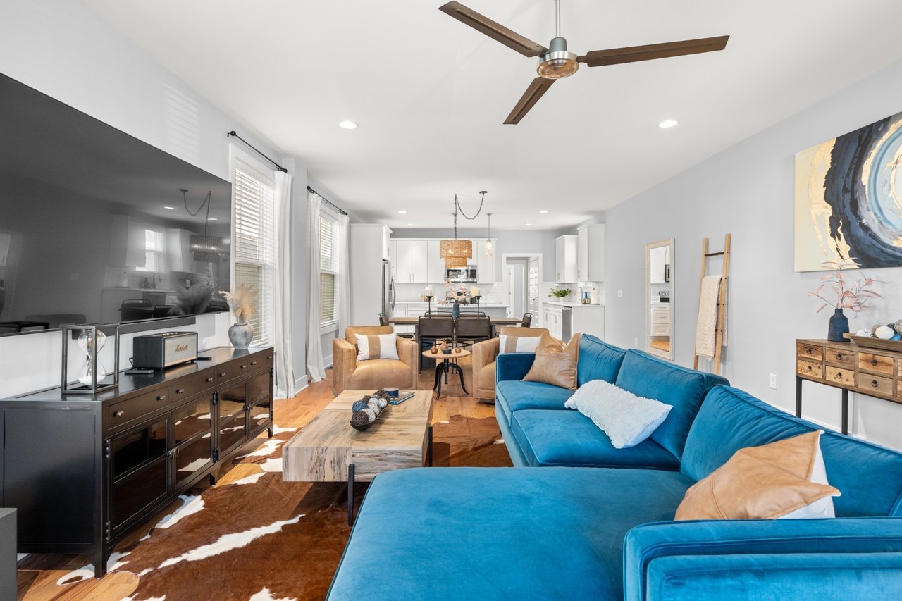 Living room at 6117 California Ave #B — blue sectional and ceiling fan