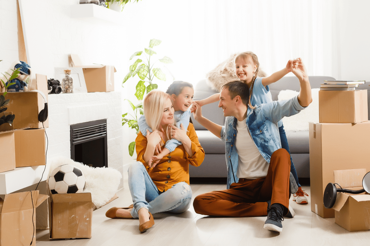 Family sitting in their new home surrounded by moving boxes after relocating