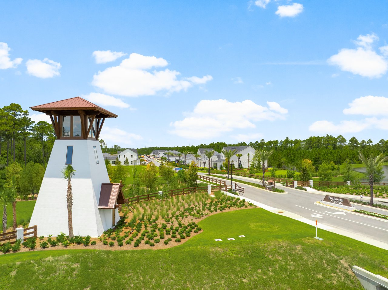 Breakwater at Ward Creek entrance with a white lighthouse-style tower and homes beyond.