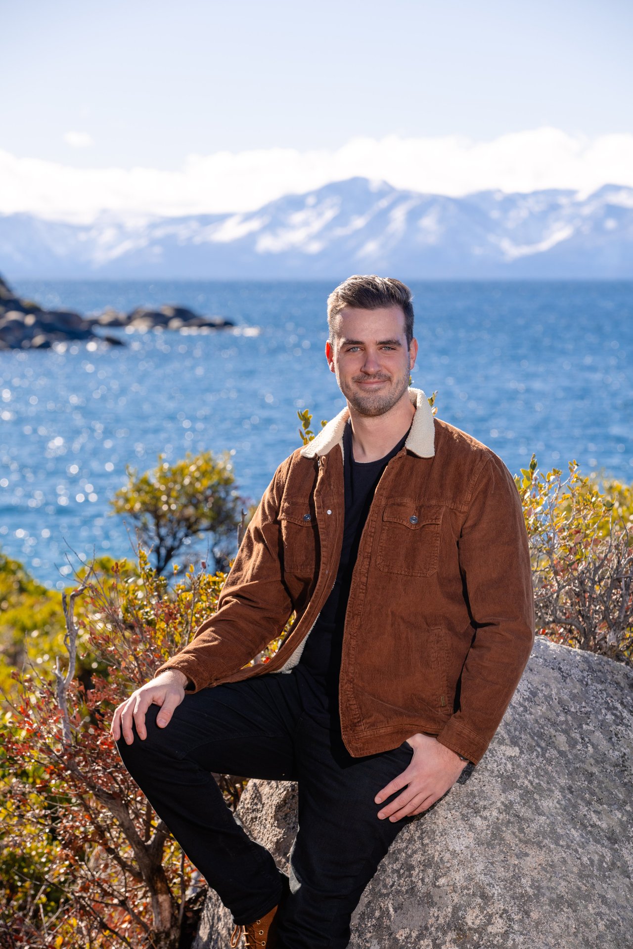Cole Mizak, Compass Lake Tahoe real estate agent, with Lake Tahoe homes and mountain views in the background
