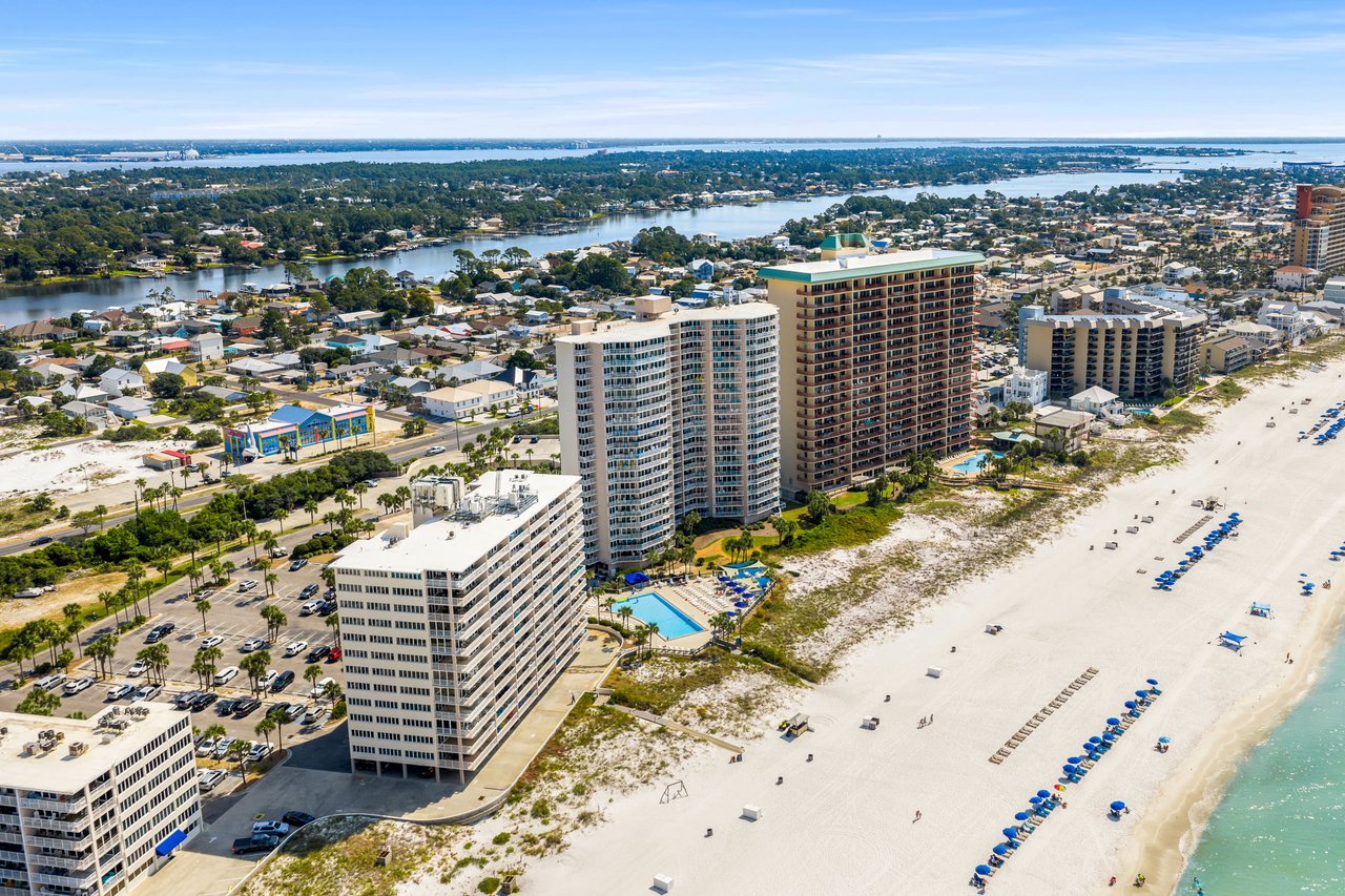 Wide aerial of Thomas Drive condos between the bay and the Gulf in Panama City Beach