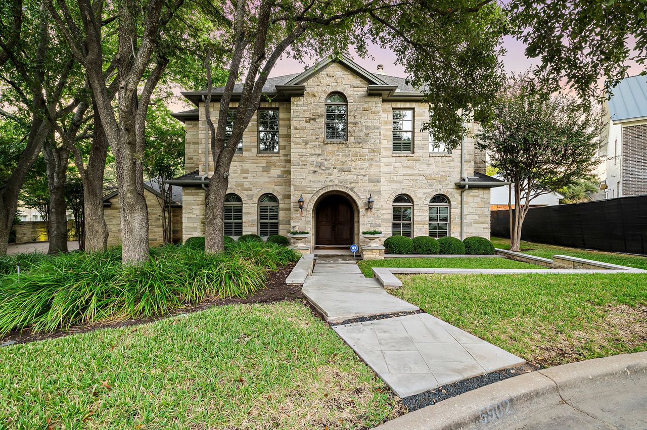Two-story stone front elevation with arched windows at 5902 Saratoga Cove in Davenport Ranch, Westlake, Austin, Texas, built by John Luce.