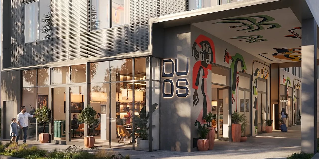 Duos Wynwood entrance with colorful murals, glass storefront, and perforated metal facade.