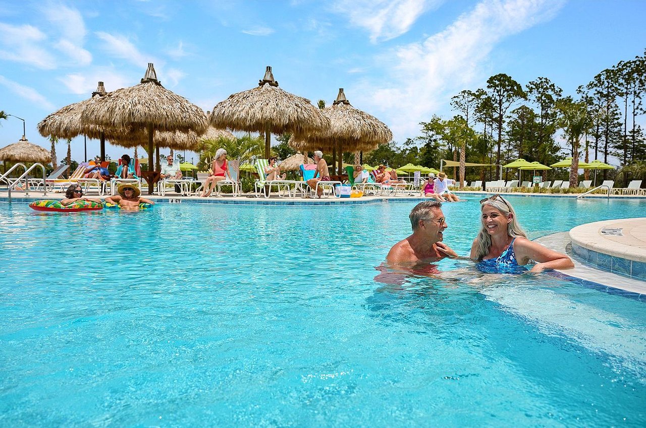 Resort style pool with tiki umbrellas and people relaxing in Panama City Beach Florida