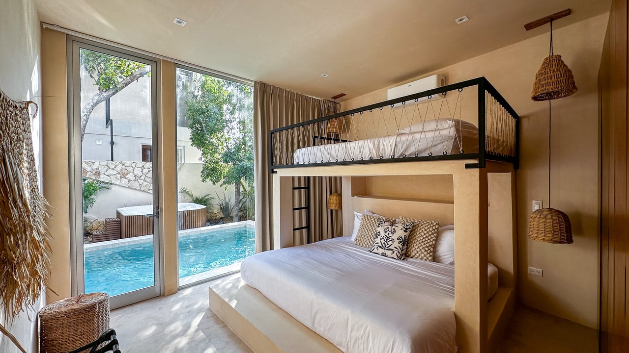 Bedroom with a black-framed loft bed and glass doors overlooking a pool.