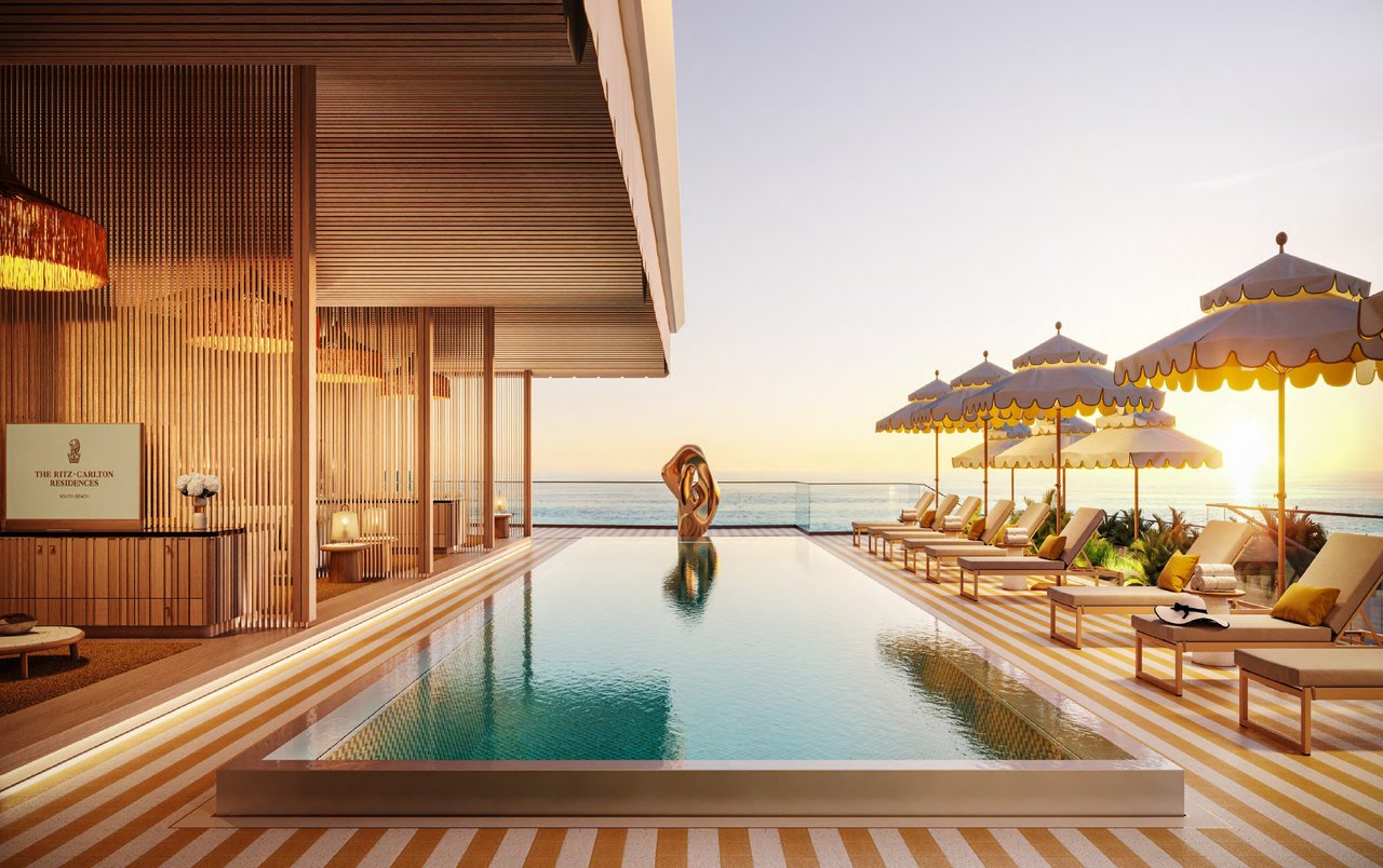 Private pool terrace at The Ritz-Carlton Residences, South Beach with lounge seating, umbrellas, ocean views, and refined resort-style design.